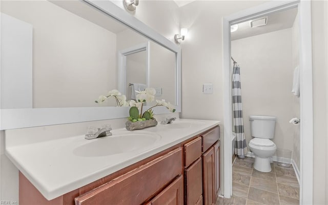 bathroom featuring double vanity, a sink, a shower with shower curtain, and toilet