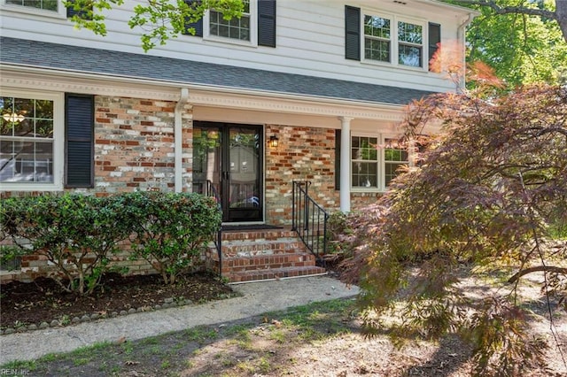 entrance to property with brick siding and covered porch