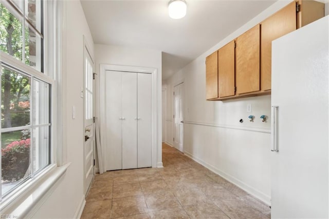 clothes washing area with baseboards, hookup for a washing machine, and cabinet space