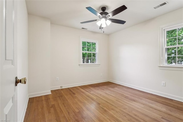 empty room with baseboards, visible vents, a healthy amount of sunlight, and light wood-style flooring