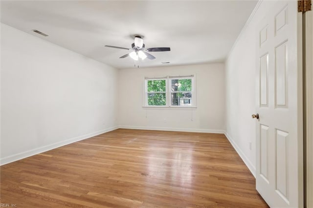 unfurnished room with baseboards, a ceiling fan, light wood finished floors, and visible vents