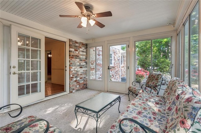 sunroom / solarium featuring a ceiling fan, plenty of natural light, and french doors