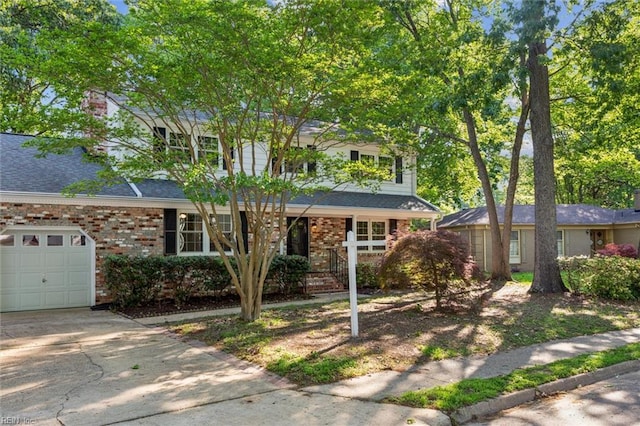 view of front facade with a shingled roof, brick siding, a garage, a porch, and concrete driveway