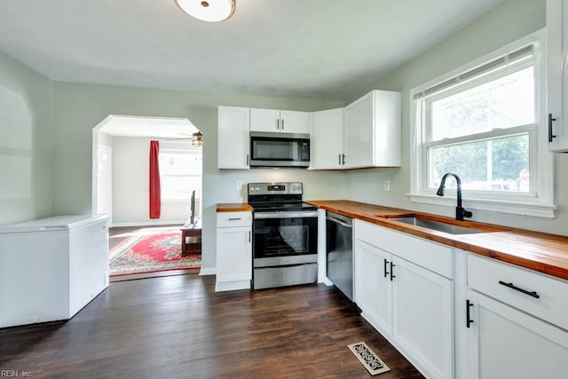 kitchen featuring visible vents, a sink, appliances with stainless steel finishes, and wooden counters