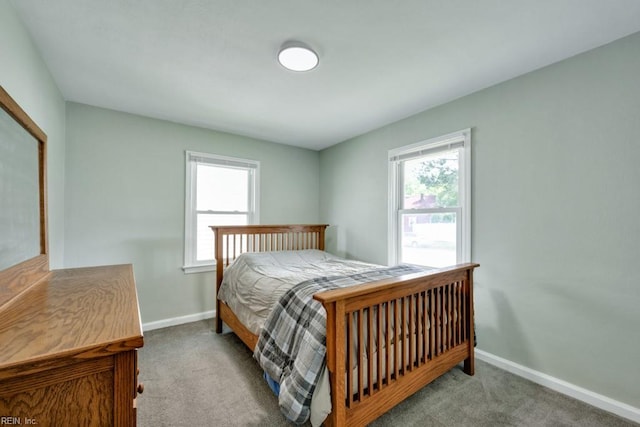 bedroom with carpet floors, baseboards, and multiple windows