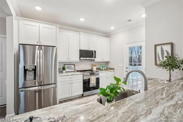 3009 Ridge Dr, Toano, VA 23168 - kitchen with crown molding, white cabinets, light stone countertops, and stainless steel appliances