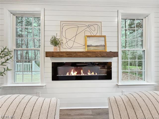 3009 Ridge Dr, Toano, VA 23168 - details featuring wooden walls, a glass covered fireplace, and wood finished floors