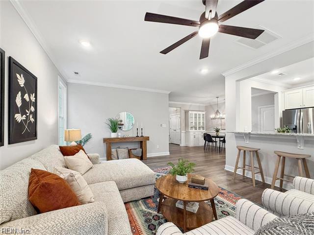 3009 Ridge Dr, Toano, VA 23168 - living room with visible vents, crown molding, wood finished floors, baseboards, and ceiling fan with notable chandelier