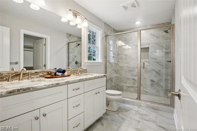 3009 Ridge Dr, Toano, VA 23168 - full bath with a sink, double vanity, toilet, marble finish floor, and a stall shower