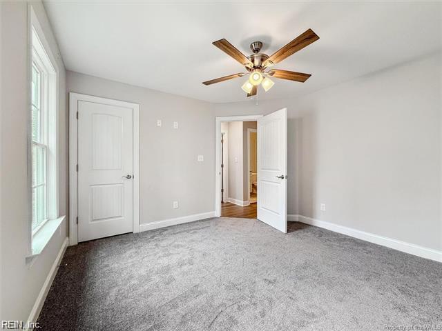 3009 Ridge Dr, Toano, VA 23168 - unfurnished bedroom with baseboards, multiple windows, ceiling fan, and carpet