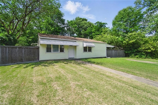 view of front facade with a front lawn and fence