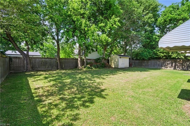 view of yard featuring a fenced backyard, an outdoor structure, and a shed