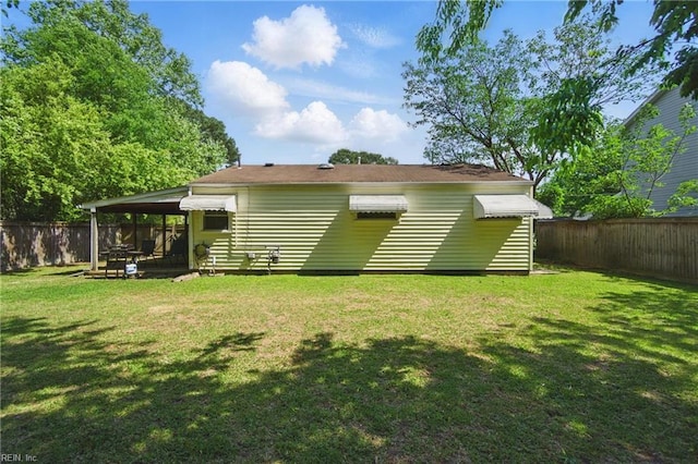 back of house with a lawn and a fenced backyard