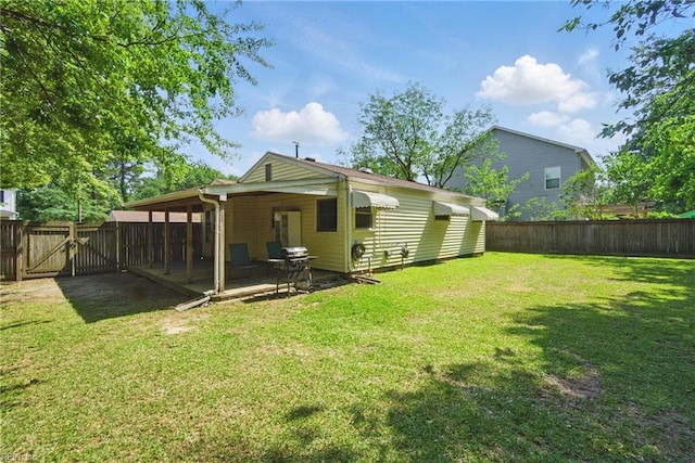 rear view of property with a yard, a gate, and a fenced backyard