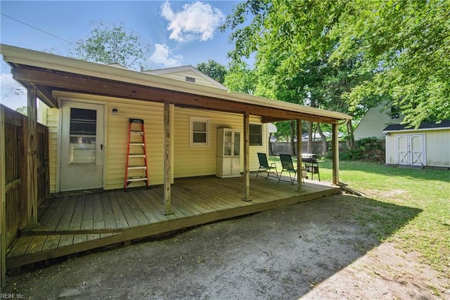 rear view of property featuring a lawn, an outbuilding, a fenced backyard, and a wooden deck