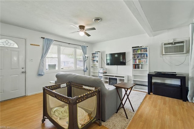 living room featuring visible vents, ceiling fan, and wood finished floors