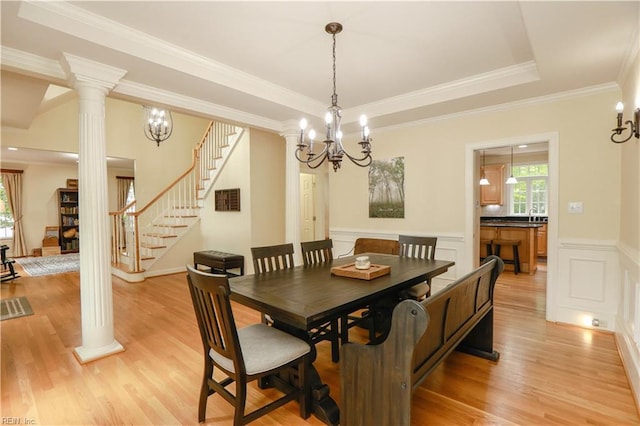 dining space featuring decorative columns, a healthy amount of sunlight, and stairway