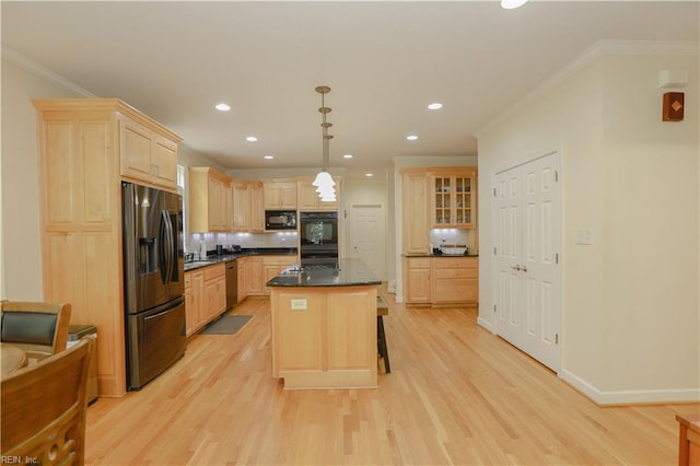 kitchen with light brown cabinetry, dark countertops, black appliances, and light wood-style floors