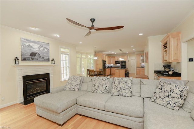 living room featuring crown molding, recessed lighting, light wood finished floors, and ceiling fan