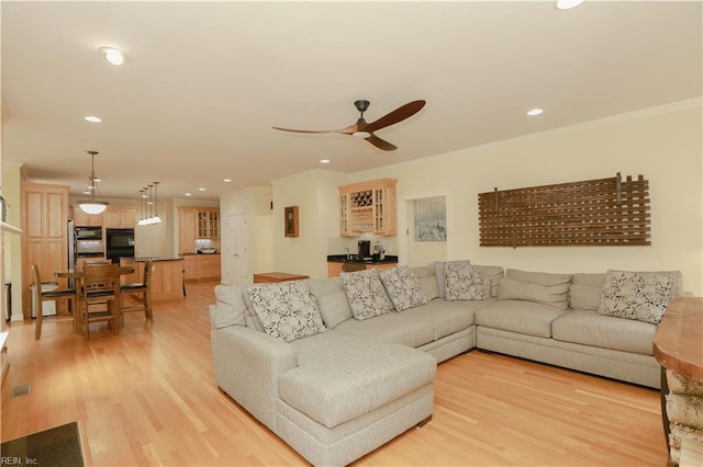living room with crown molding, a ceiling fan, recessed lighting, and light wood-style floors