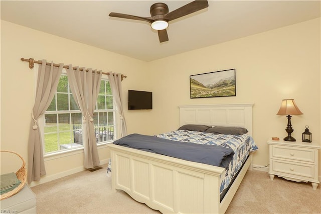 bedroom with baseboards, ceiling fan, and light colored carpet