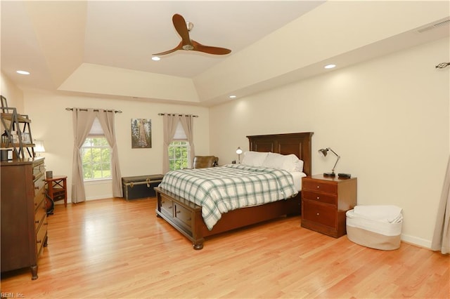 bedroom featuring visible vents, a raised ceiling, baseboards, light wood finished floors, and recessed lighting