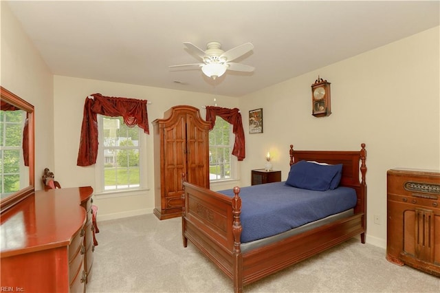 bedroom featuring baseboards, light carpet, and a ceiling fan
