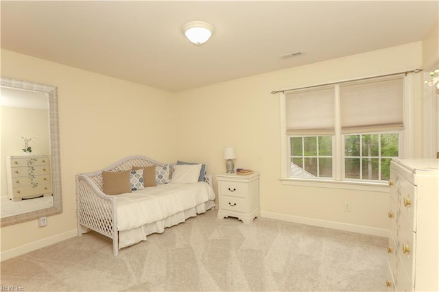 bedroom featuring baseboards, visible vents, and light colored carpet
