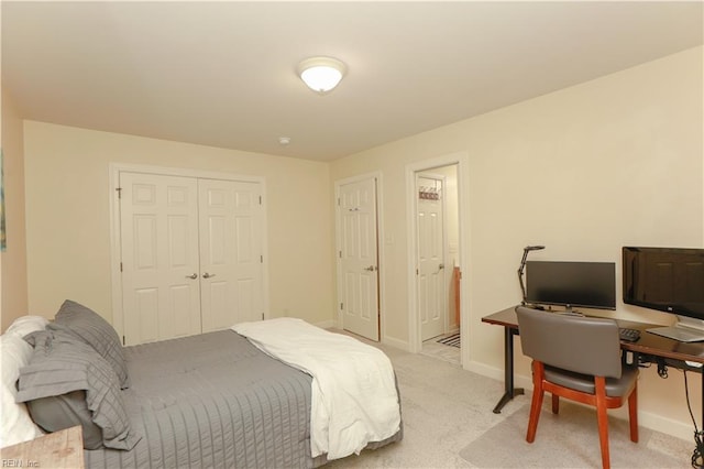 bedroom featuring baseboards, light colored carpet, and a closet