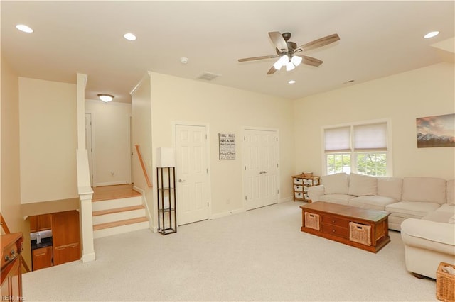 living room featuring ceiling fan, light colored carpet, visible vents, baseboards, and recessed lighting