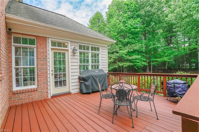 wooden deck featuring outdoor dining space and a grill