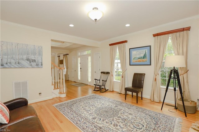 sitting room featuring ornamental molding, stairs, wood finished floors, and visible vents