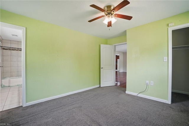unfurnished bedroom with baseboards, ceiling fan, carpet, and a closet