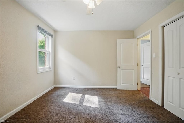 unfurnished bedroom with baseboards, carpet flooring, ceiling fan, and a closet