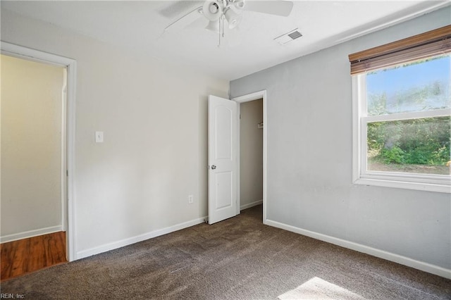 unfurnished bedroom featuring baseboards, a ceiling fan, carpet flooring, and visible vents