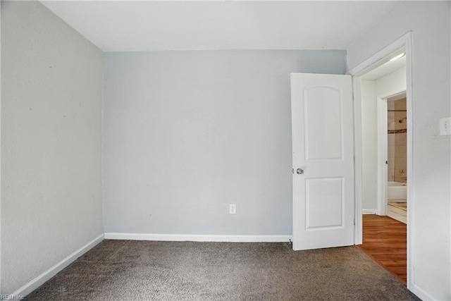 spare room featuring carpet floors and baseboards