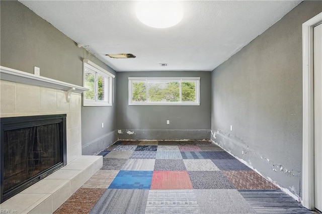 unfurnished living room featuring visible vents, baseboards, a healthy amount of sunlight, and a fireplace