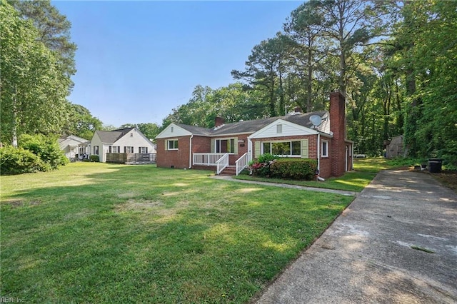 bungalow featuring brick siding, a front lawn, and a chimney