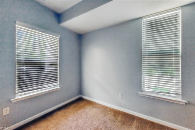 empty room with baseboards and carpet