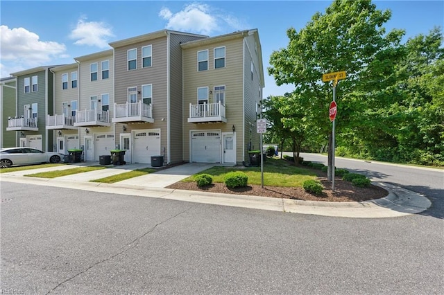 multi unit property with an attached garage, driveway, and central AC unit