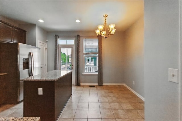 kitchen featuring stainless steel refrigerator with ice dispenser, baseboards, a chandelier, and light tile patterned floors