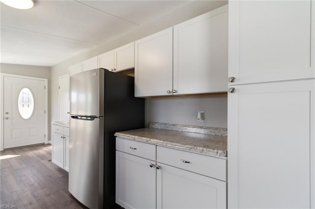 kitchen featuring freestanding refrigerator, dark wood finished floors, and white cabinetry
