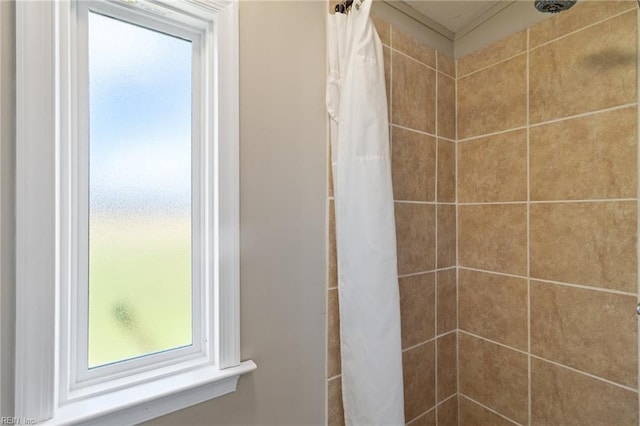 full bathroom with a tile shower and plenty of natural light
