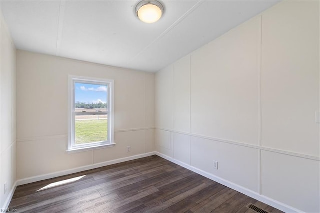 empty room featuring baseboards and dark wood-style flooring