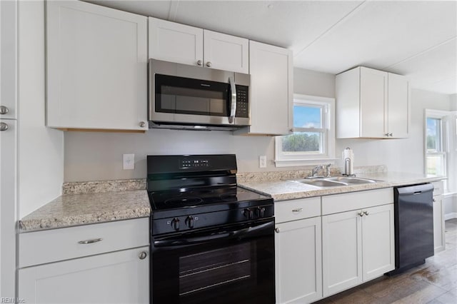 kitchen featuring light countertops, stainless steel microwave, black electric range oven, and dishwashing machine