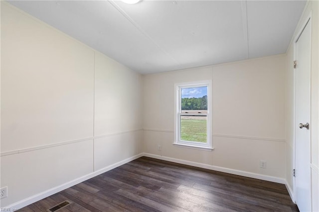 spare room with baseboards, wood finished floors, and visible vents