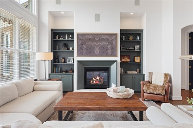 living room featuring a glass covered fireplace and wood finished floors