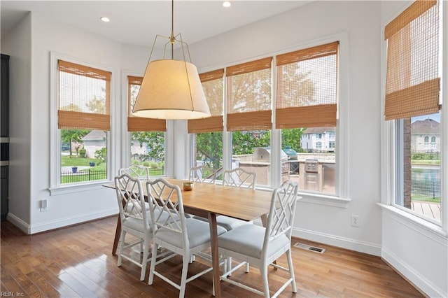 dining space with a healthy amount of sunlight, wood finished floors, and visible vents