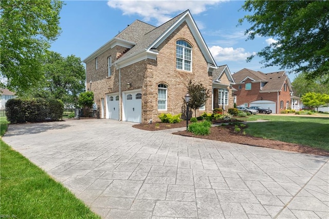 view of front of property with brick siding, a front lawn, an attached garage, and driveway
