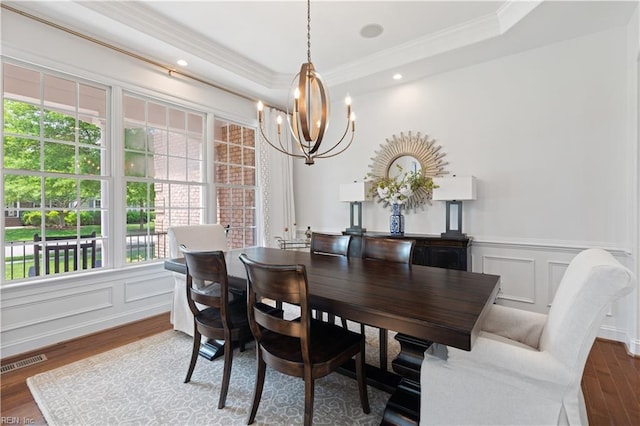 dining area featuring an inviting chandelier, plenty of natural light, a decorative wall, and visible vents